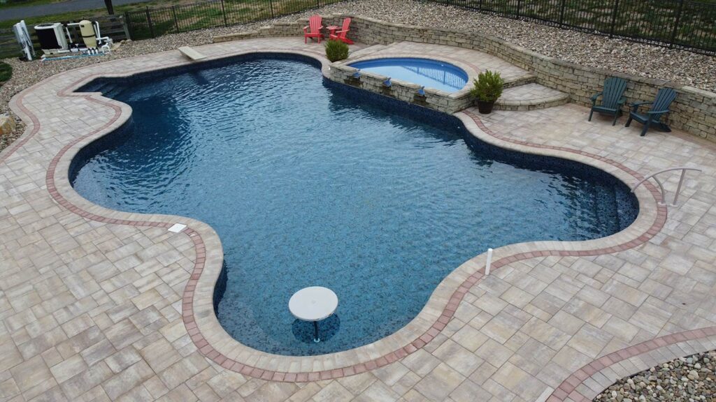 An inground swimming pool with landscaping.