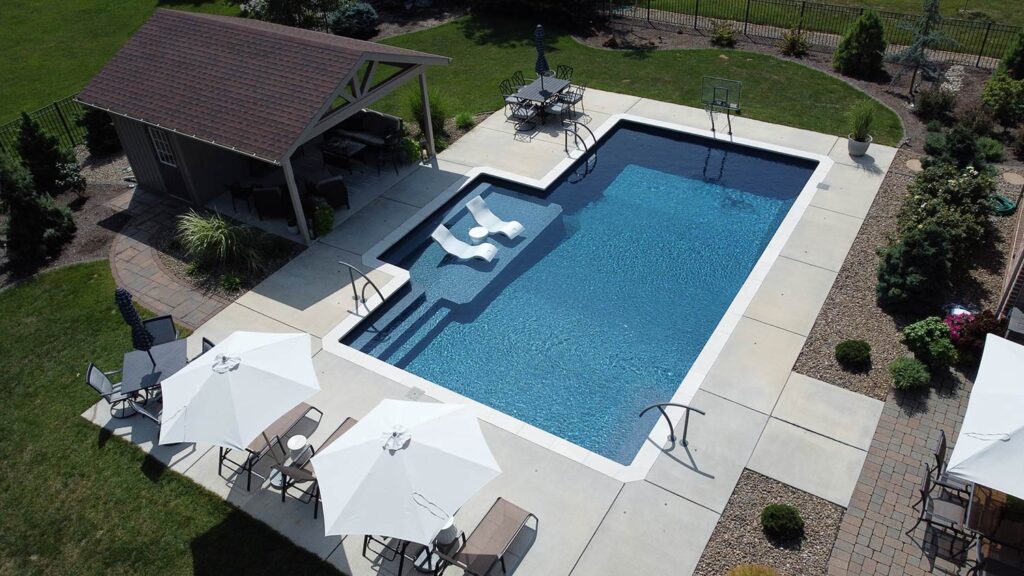 View from above an inground pool with a pool house.