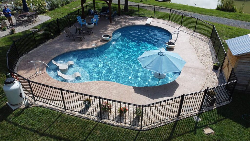 A kindney-shaped pool with custom fencing.