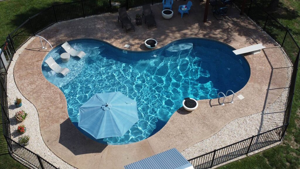 Aerial view of a kidney-shaped pool with a diving board.