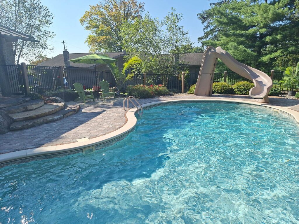 A landscaped area with a swimming pool and slide.