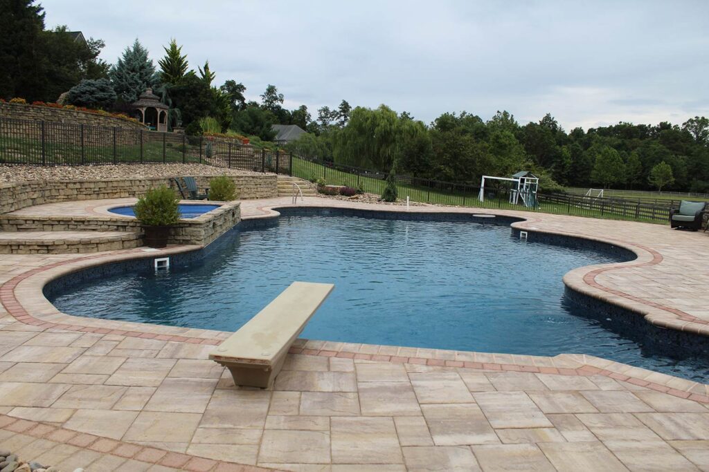 A swimming pool sits among a custom landscape.