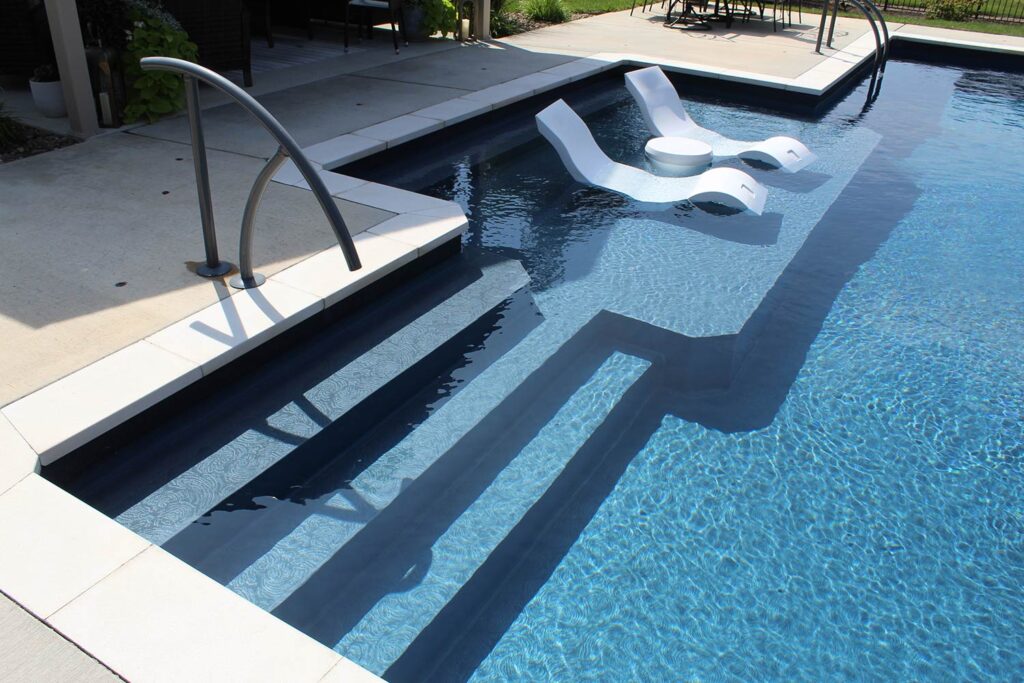 A look at the steps and lounge area entering a pool.